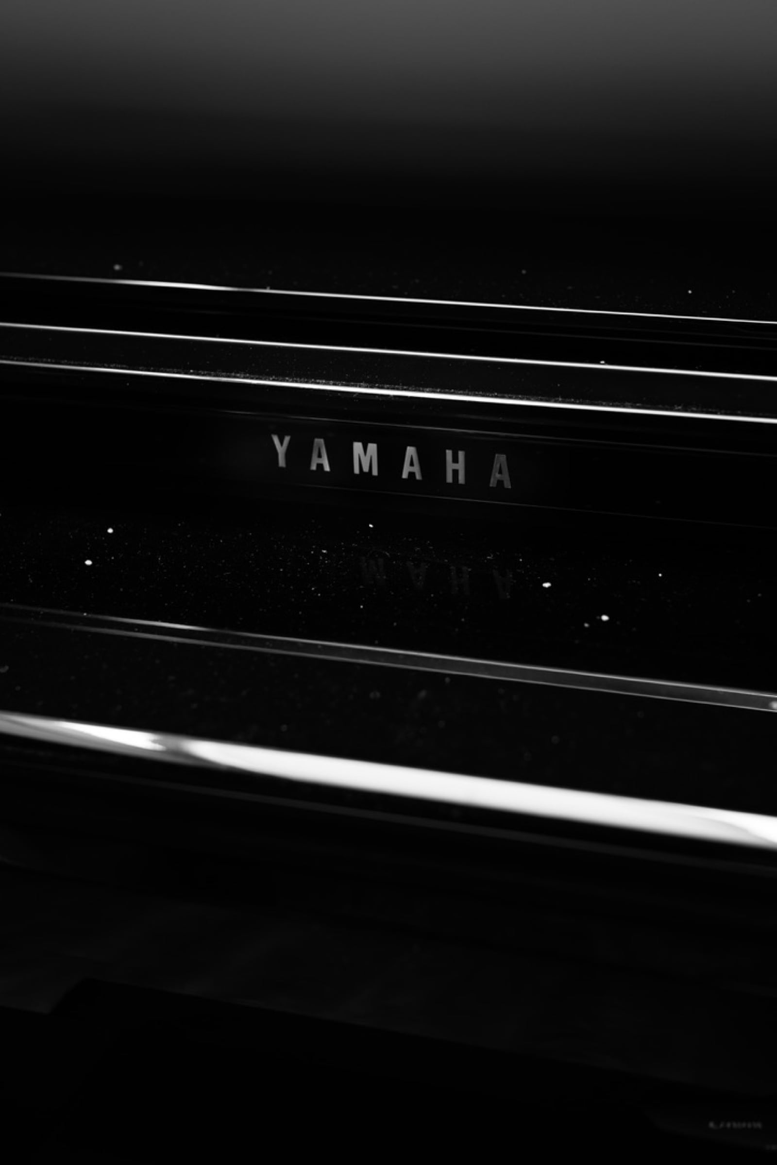 Černobílý detail lesklého klavíru Yamaha